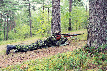 Image showing young soldier or hunter with gun in forest