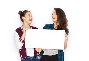 Image showing smiling teenage girls holding white blank board