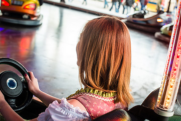 Image showing Beautiful girl in an electric bumper car in amusement park