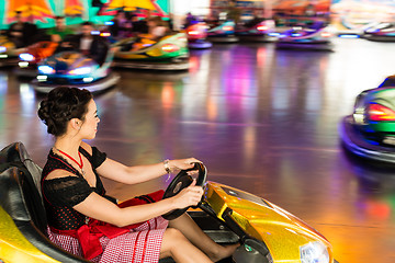 Image showing Beautiful girl in an electric bumper car at amusement park