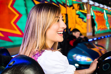 Image showing Beautiful girl in an electric bumper car at amusement park
