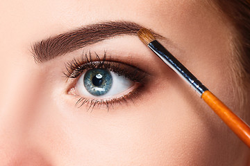 Image showing Beautiful female eyes with bright blue make-up and brush