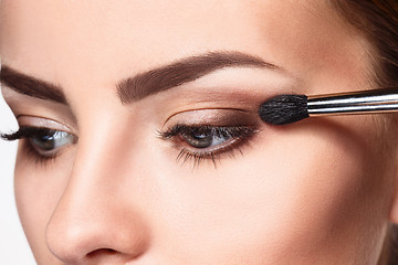 Image showing Beautiful female eyes with bright blue make-up and brush