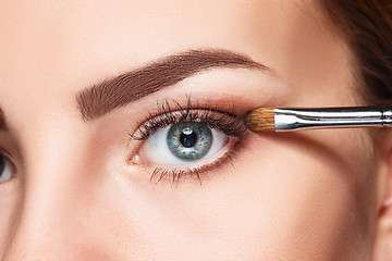 Image showing Beautiful female eyes with bright blue make-up and brush