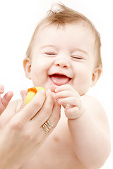 Image showing laughing baby boy in mother hands with rubber duck