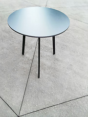 Image showing Round metal table on concrete floor