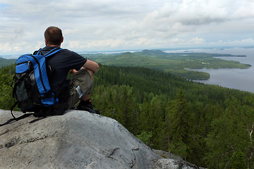 Image showing tourist sits on a cliff in the national park Koli, Finland