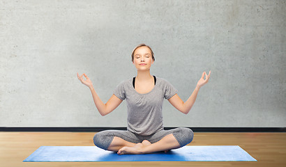 Image showing woman making yoga meditation in lotus pose on mat