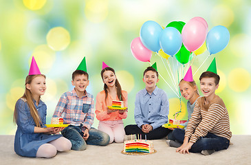 Image showing happy children in party hats with birthday cake