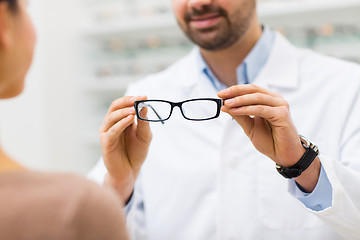 Image showing close up of optician with glasses at optics store