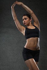 Image showing young woman posing and showing muscles in gym