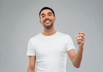 Image showing smiling man with male perfume over gray background