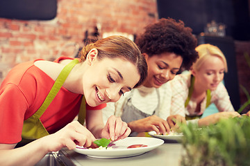 Image showing happy women cooking and decorating dishes