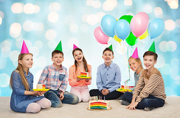 Image showing happy children in party hats with birthday cake