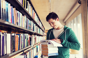 Image showing happy student or man with book in library