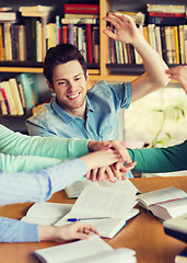 Image showing students with books and hands on top in library