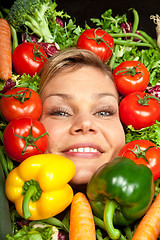 Image showing Cute blond girl shot in studio with vegetables aroound the head