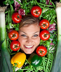 Image showing Cute blond girl shot in studio with vegetables aroound the head