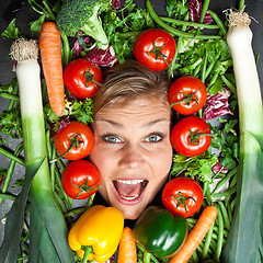 Image showing Cute blond girl shot in studio with vegetables aroound the head