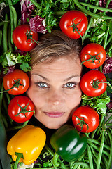 Image showing Cute blond girl shot in studio with vegetables aroound the head