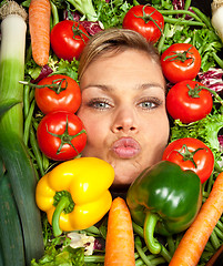 Image showing Cute blond girl shot in studio with vegetables aroound the head