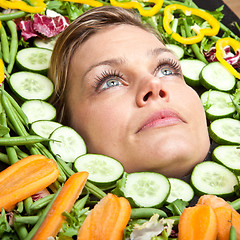 Image showing Cute blond girl shot in studio with vegetables aroound the head