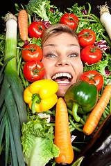 Image showing Cute blond girl shot in studio with vegetables aroound the head