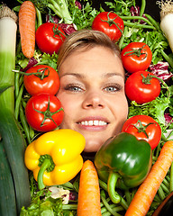 Image showing Cute blond girl shot in studio with vegetables aroound the head