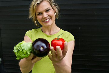 Image showing Cute blond girl presenting vegetables
