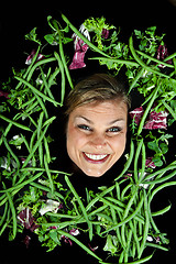 Image showing Cute blond girl shot in studio with vegetables aroound the head