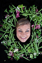 Image showing Cute blond girl shot in studio with vegetables aroound the head