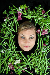 Image showing Cute blond girl shot in studio with vegetables aroound the head