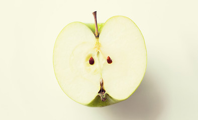 Image showing ripe green apple half over white