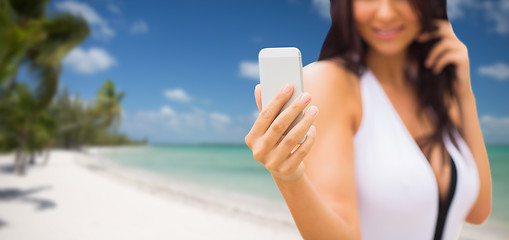 Image showing young woman taking selfie with smartphone on beach