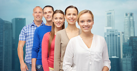 Image showing group of smiling people over city buildings