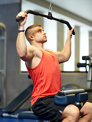 Image showing man flexing muscles on cable machine gym