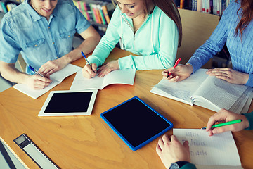 Image showing happy students writing to notebooks in library