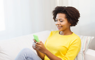 Image showing happy african woman with smartphone at home