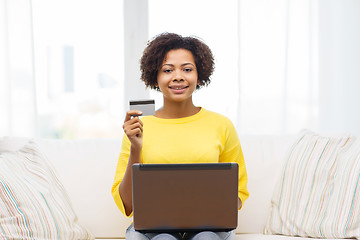 Image showing happy african woman with laptop and credit card