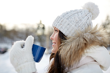 Image showing happy young woman with tea cup outdoors in winter