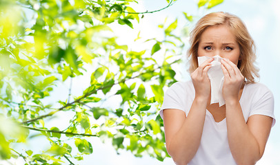 Image showing unhappy woman with paper napkin blowing nose