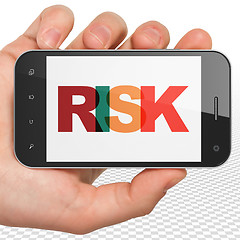 Image showing Finance concept: Hand Holding Smartphone with Risk on  display