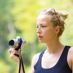 Image showing Woman in nature with retro camera.