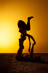 Image showing Two people practicing yoga in the sunset light