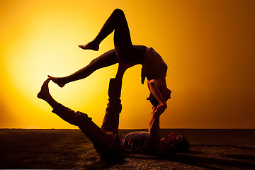 Image showing Two people practicing yoga in the sunset light