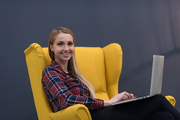 Image showing startup business, woman  working on laptop and sitting on yellow