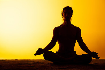 Image showing The man practicing yoga in the sunset light