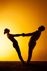 Image showing Two people practicing yoga in the sunset light