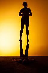 Image showing Two people practicing yoga in the sunset light