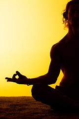 Image showing The man practicing yoga in the sunset light